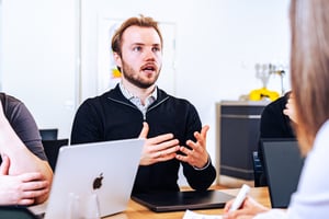 The image shows a UNIwise employee in a meeting
