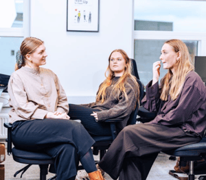 Female group of employees talking informally at their desks at the Aarhus UNIwise office
