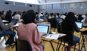 Students taking an assessment on their laptops in an exam hall